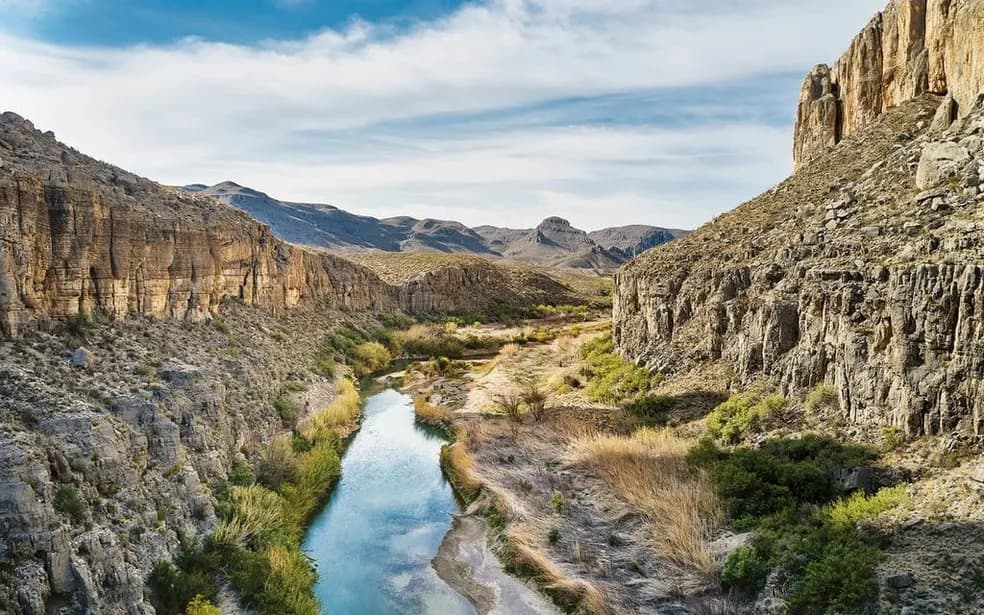 Wide overlook down a desert canyon to a green stretch of river