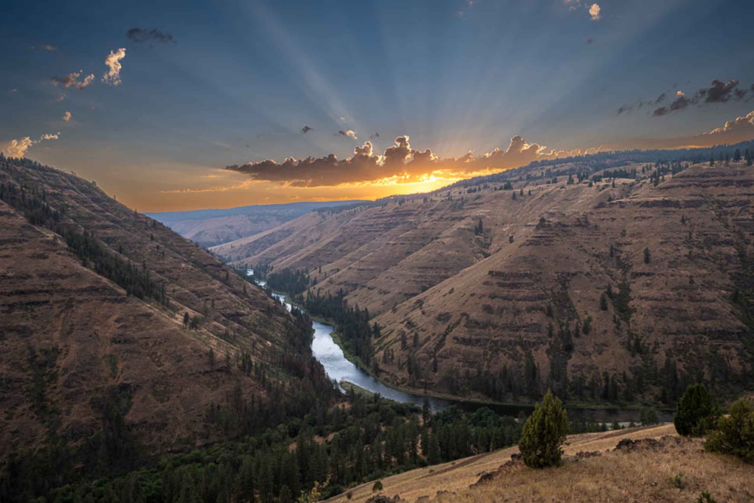 Sunburst over the canyon rim with the river below